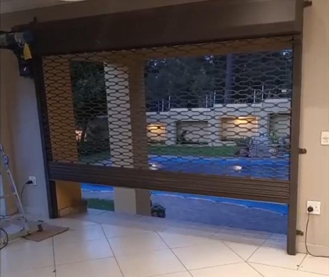 Perforated roller shutter door keeping a shopfront display visible after hours