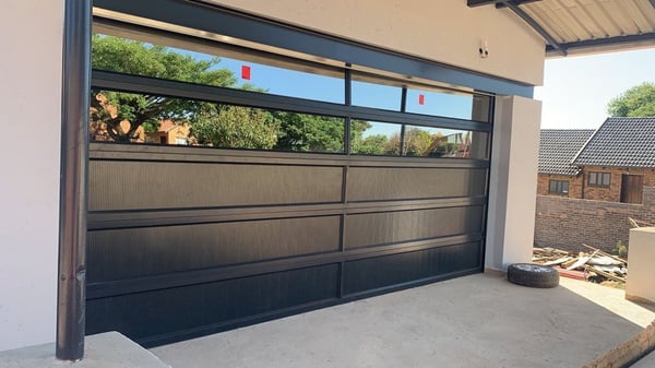Full-view aluminium garage door with glazed panels on a double garage