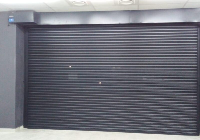 Dark ribbed roll-up garage door fitted to a modern double garage