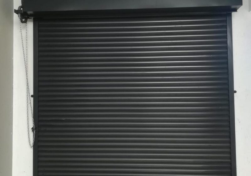 Row of black roll-up garage doors on a terrace of garages